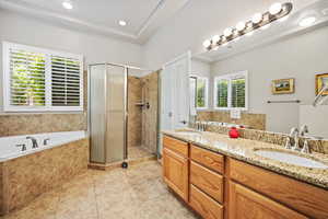 Bathroom featuring tile patterned flooring, a shower stall, double vanity, a garden tub, and recessed lighting