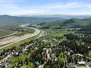 Aerial view of property's location with mountains and nearby suburban area