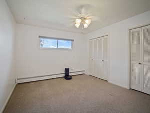 Unfurnished bedroom featuring two closets, carpet flooring, and baseboards
