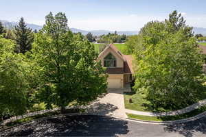 View of front facade with driveway, stucco siding, a garage, and a mountain view