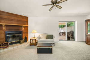 Living room with a ceiling fan, a fireplace, and baseboards