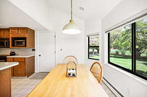 Dining room featuring plenty of natural light, light tile patterned floors, and a baseboard radiator