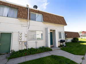 View of front of house with a shingled roof, mansard roof, and a front lawn