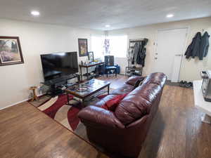 Living area with wood finished floors and recessed lighting