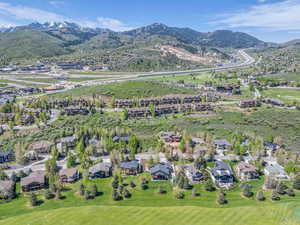 View of property location featuring nearby suburban area, a mountainous background, and a local golf course
