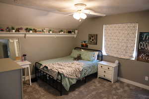 Bedroom featuring dark carpet, lofted ceiling, ceiling fan, and baseboards
