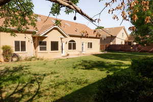Back of property with stucco siding and a tiled roof