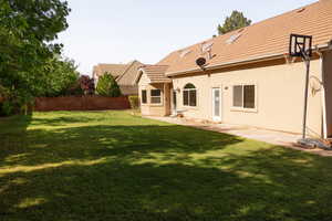 Back of house with stucco siding, a tiled roof, and a patio