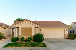 Ranch-style house with driveway, a garage, and a tile roof