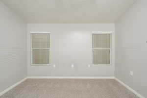 Unfurnished room featuring carpet floors and baseboards