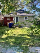 Back of property featuring a chimney and a yard