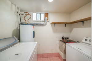 Laundry area featuring electric water heater and separate washer and dryer