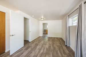 Spare room featuring wood finished floors and baseboards