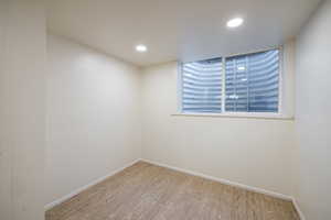 Spare room featuring wood finished floors, baseboards, and recessed lighting