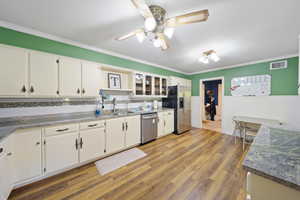 Kitchen featuring appliances with stainless steel finishes, a sink, crown molding, a ceiling fan, and white cabinets