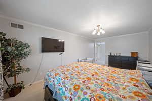 Carpeted bedroom featuring crown molding, a chandelier, and baseboards