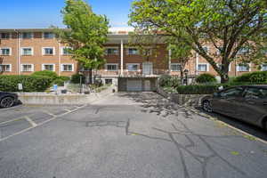 View of building exterior featuring an attached garage and driveway