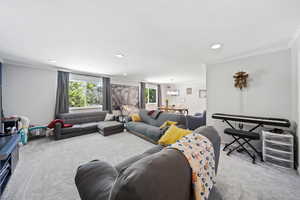 Carpeted living room featuring crown molding and recessed lighting