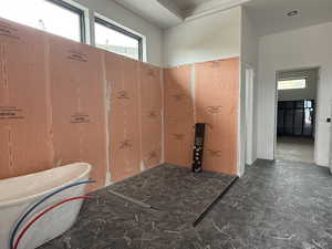 Full bathroom with stone floors and a freestanding bath