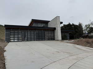 View of front facade featuring concrete driveway, stucco siding, and an attached garage