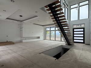 Unfurnished living room with a raised ceiling and recessed lighting