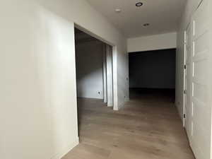 Hall with light wood-style flooring and baseboards