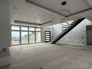 Unfurnished living room featuring a tray ceiling, light wood-style floors, recessed lighting, and a mountain view