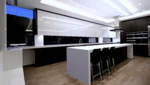 Kitchen with modern cabinets, exhaust hood, light wood-style floors, a kitchen island, and dark cabinets
