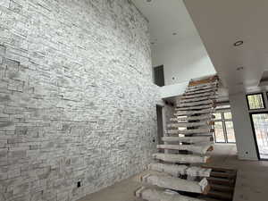 Staircase featuring a high ceiling and recessed lighting