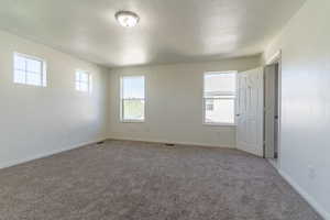 Empty room featuring light carpet and baseboards