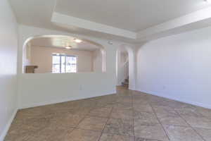 Unfurnished room with a tray ceiling and baseboards