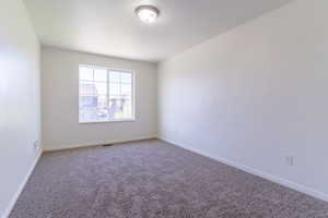 Carpeted empty room featuring baseboards