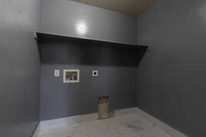 Washroom featuring hookup for an electric dryer, washer hookup, baseboards, light marble finish floors, and a textured ceiling