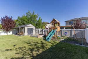 View of playground featuring a shed and an outbuilding