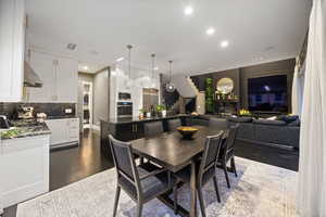 Dining area with a glass covered fireplace, recessed lighting, and dark wood finished floors
