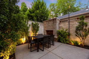 View of patio / terrace with outdoor dining area and an outdoor stone fireplace