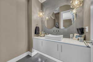 Bathroom featuring baseboards, tile patterned flooring, and vanity