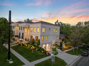 View of front facade featuring driveway, an attached garage, a yard, and stucco siding