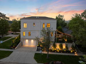 View of front of property featuring a garage, driveway, stairway, a front lawn, and stucco siding