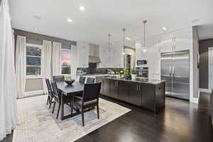 Kitchen featuring built in appliances, baseboards, white cabinetry, backsplash, and recessed lighting