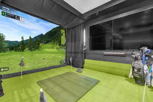 Playroom with golf simulator, a mountain view, and carpet flooring
