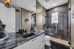 Full bath featuring toilet, a shower stall, vanity, and recessed lighting