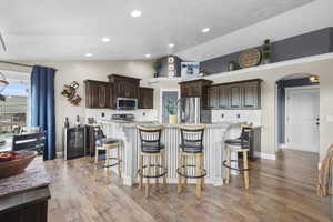 Kitchen with stainless steel appliances, vaulted ceiling, tasteful backsplash, upgraded cabinetry