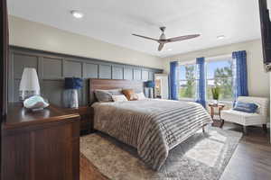 Primary bedroom with featured board and batten wall and natural light
