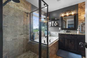 Primary bathroom with separate shower and jetted tub, granite countertops and vanity