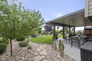 View of grassy yard with a patio area