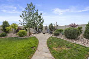 View of yard featuring rocked walkway and a fire pit area