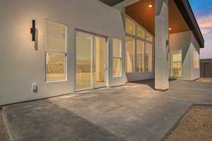 Back of house with stucco siding and a patio area