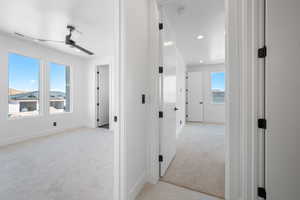 Hallway featuring light carpet, baseboards, and recessed lighting