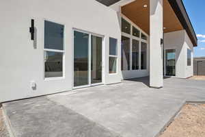 Rear view of property featuring stucco siding and a patio area